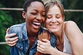 Patient in Arlington with dental implants smiling with a friend