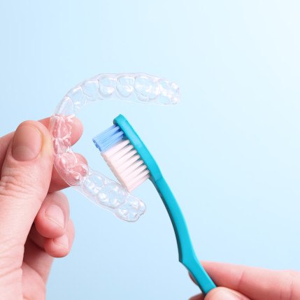 Patient cleaning clear aligner with toothbrush