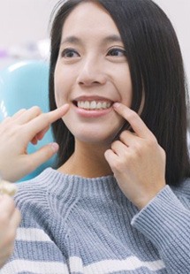 Dentist pointing to a dental implant model